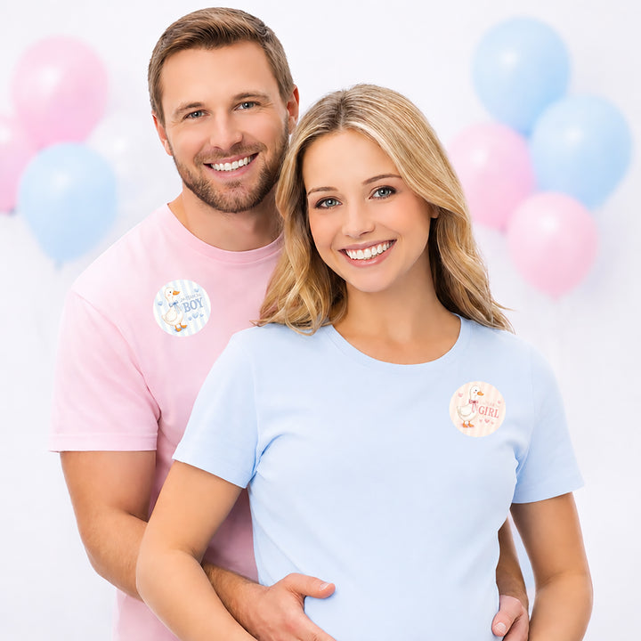A smiling man and woman pose together wearing silly goose gender reveal stickers.