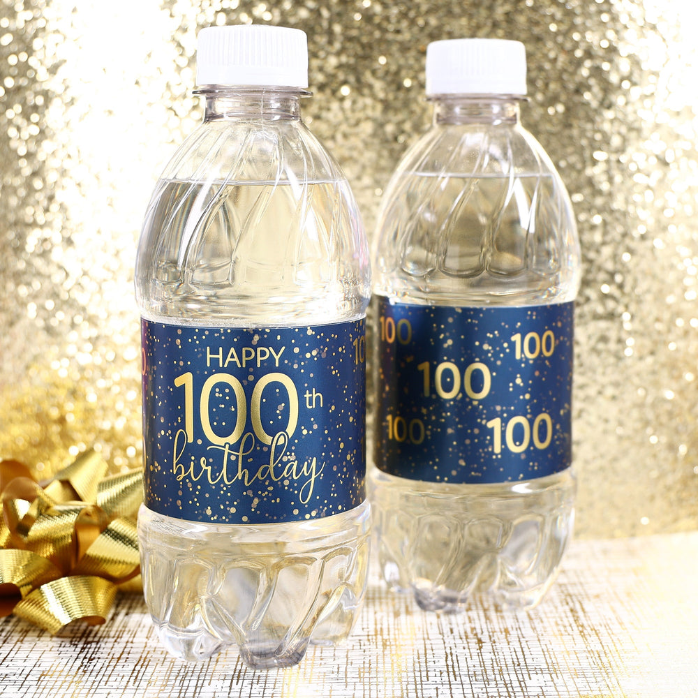 A close-up view of a navy blue water bottle label with gold lettering that reads "Happy 100th Birthday" and features a sleek, modern design
